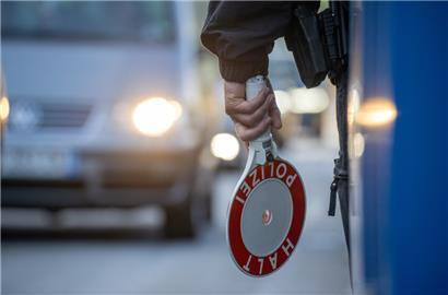 Ein Bundespolizist steht mit einer Kelle an einer Kontrollstelle auf der A64 bei Trier
