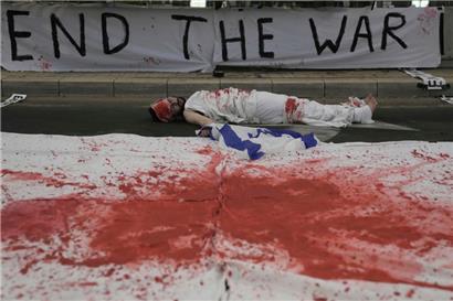 Ein Demonstrant liegt während einer Demonstration, die das Ende des Krieges, die sofortige Freilassung der von der Hamas im Gazastreifen festgehaltenen Geiseln und die Ablehnung der Regierung von Ministerpräsident Netanjahu fordert, auf dem mit roter Farbe, die Blut symbolisiert, bemalten Boden
