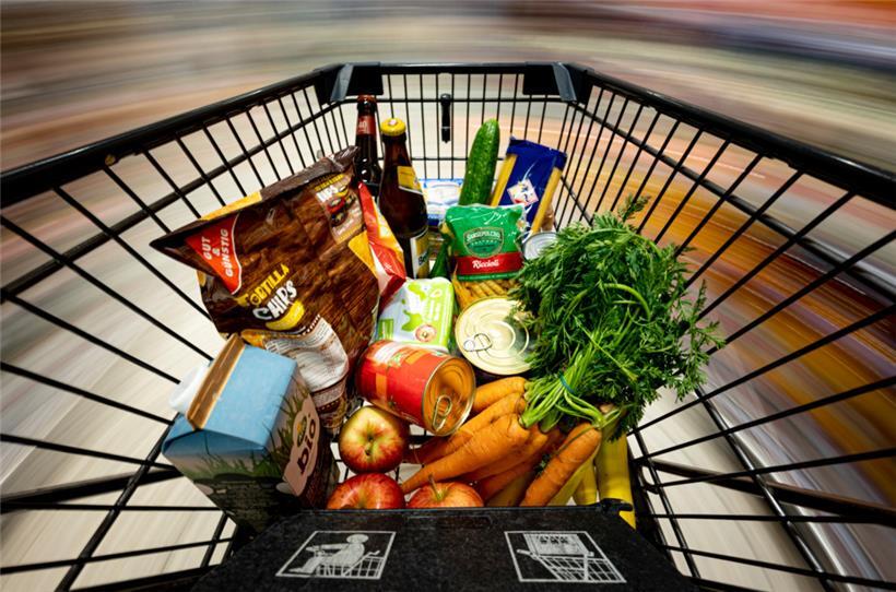 Ein Einkauf liegt in einem Einkaufswagen in einem Supermarkt.
