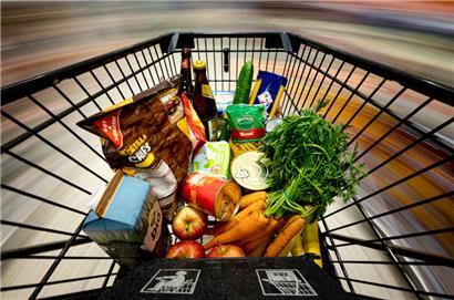 Ein Einkauf liegt in einem Einkaufswagen in einem Supermarkt.
