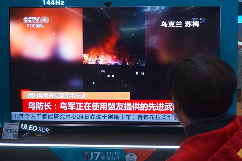 Ein Einwohner sieht sich in einem Einkaufszentrum in Hangzhou in der ostchinesischen Provinz Zhejiang Nachrichten über den Konflikt zwischen Russland und der Ukraine an
