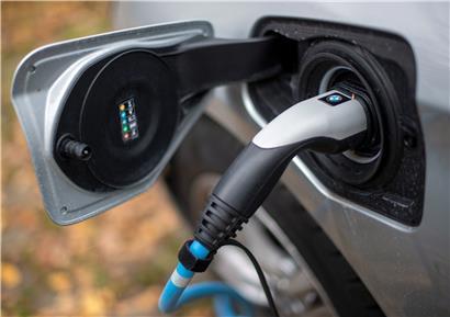 Ein Elektroauto von BMW wird an einer Ladesäule geladen. 
