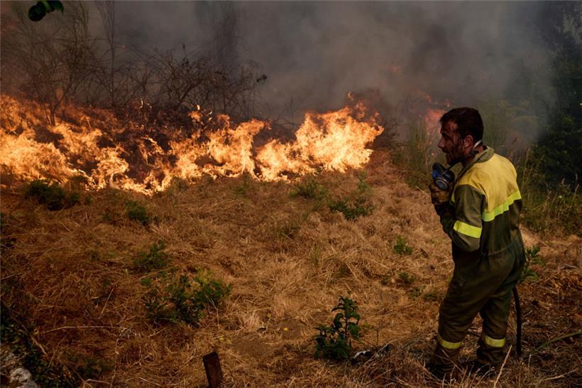 Ein Feuerwehrmann bekämpft ein Feuer, das sich auf das Dorf Rebordondo in der Nähe von Ourense im Nordwesten Spaniens ausbreitet
