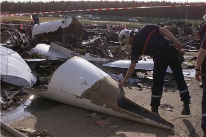 Ein Feuerwehrmann berührt die Nase der Concorde am Absturzort. 
