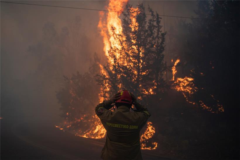 Ein Feuerwehrmann rückt seinen Helm im Dorf Varnava während eines Waldbrandes zurecht, während in vielen Regionen des Landes aufgrund der hohen Temperaturen und Windgeschwindigkeiten höchste Alarmbereitschaft herrscht
