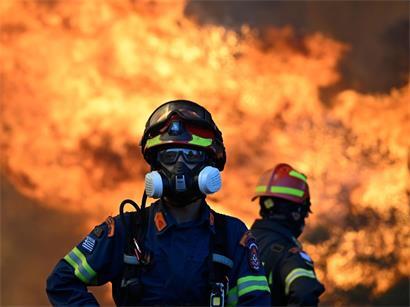 Ein Feuerwehrmann steht vor den lodernden Flammen eines Waldbrands in der Nähe von Porto Germeno, nordwestlich von Athen