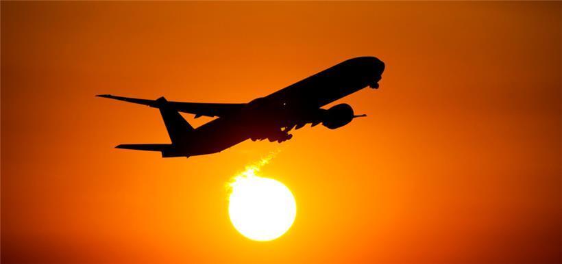 Ein Flugzeug startet vom Flughafen in Frankfurt am Main in den Sonnenuntergang
