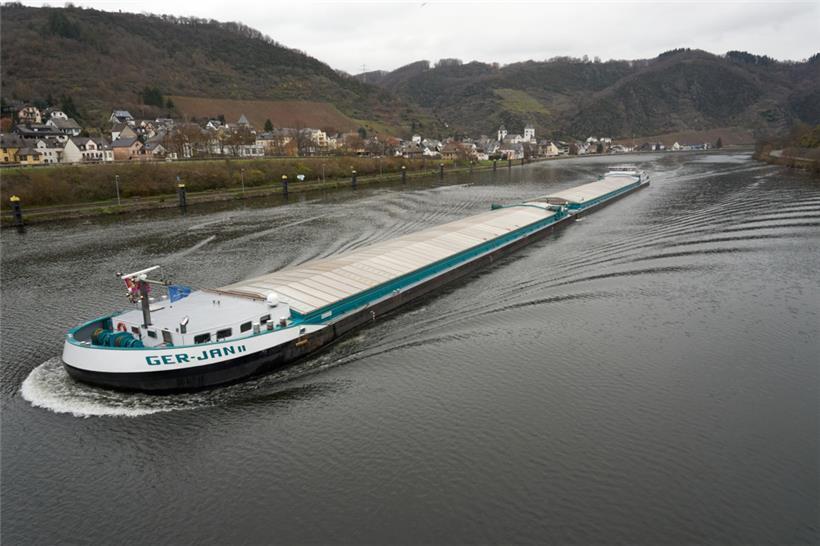 Ein Frachtschiff fährt am Moselort Karden vorbei
