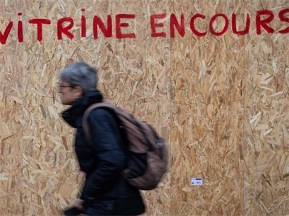Ein Fußgänger in Paris läuft an den Spuren der Proteste vorbei: Die Schüler und Studenten wollen diese weiterführen