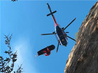 Ein GRIMP-Spezialist wird per Helikopter in das unwegsame Gelände der Berdorfer Felsformationen abgeseilt, um einen abgestürzten Kletterer zu retten
