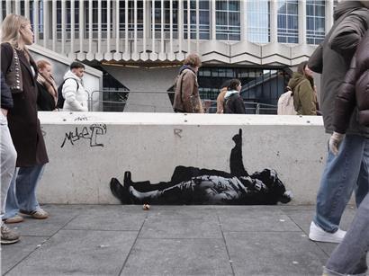 Graffiti-Kunstwerk mit zwei Personen unter Centre Point nahe Tottenham Court Road, London, möglicherweise von Banksy gestaltet