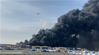 Ein Hubschrauber wirft Wasser auf das Feuer und den schwarzen Rauch, nachdem eine massive Explosion einen Hafen in der Nähe der südlichen Hafenstadt Bandar Abbas erschüttert hat
