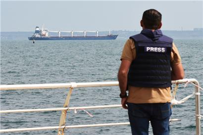 Ein Journalist beobachtet, wie das unter der Flagge von Sierra Leone fahrende Frachtschiff Razoni mit 26.000 Tonnen ukrainischem Getreide an Bord den Hafen in der Region Odessa verlässt
