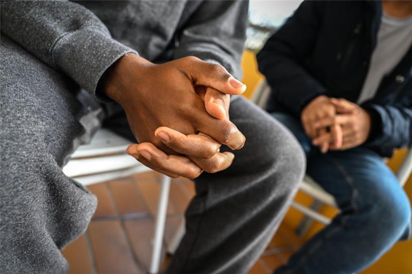 Ein Jugendlicher sitzt neben einem anderen geflüchteten Jugendlichen
