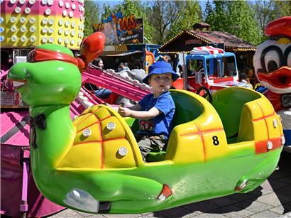 Junge auf Karussell der Cessinger Kirmes freut sich bei traditionellem Volksfest in Deutschland