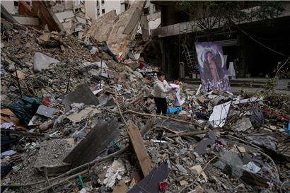 Junge hält Schulbuch in Trümmern nach Waffenstillstand zwischen Hisbollah und Israel in Dahiyeh, Beirut