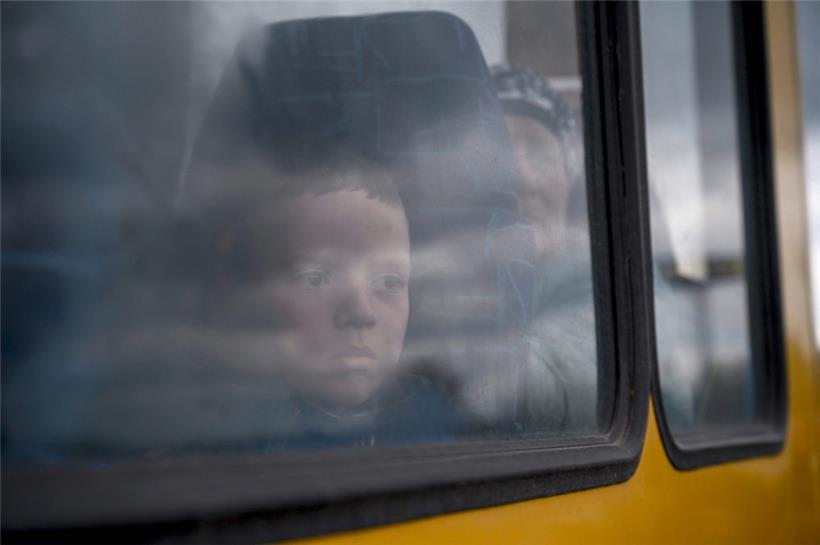 Ein Junge schaut durch das Fenster eines Busses, als Menschen, die vor den Kämpfen in Mariupol fliehen, in einem kleinen Konvoi für Binnenflüchtlinge in Saporischschja ankommen
