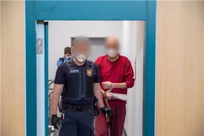 Ein Justizbediensteter begleitet den 52-jährigen Angeklagten am 15. Juli 2022 zum Prozess um die tödliche Amokfahrt in Trier in den Gerichtssaal des Landgerichts.
