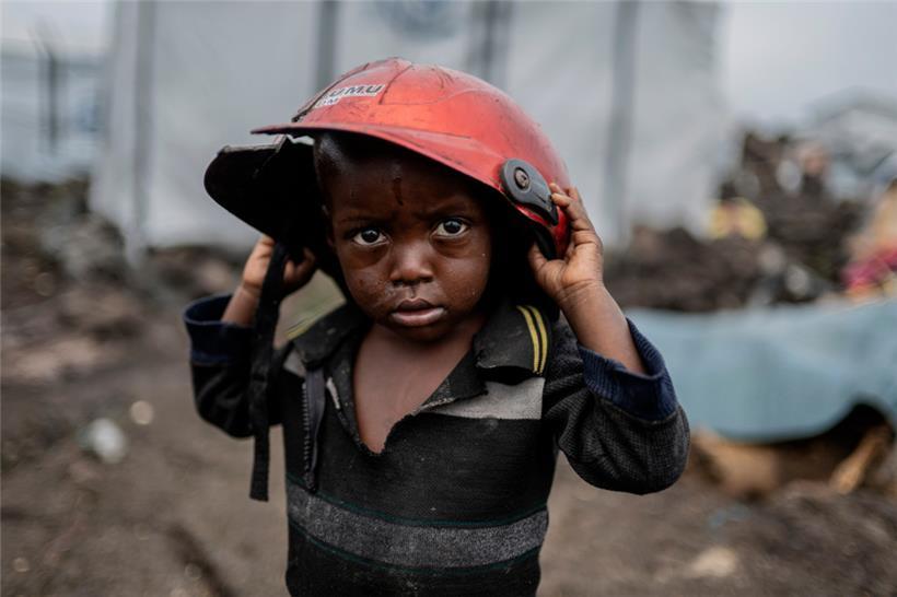 Ein Kind, das durch die Kämpfe zwischen M23-Rebellen und Regierungssoldaten vertrieben wurde, hält einen beschädigten Helm in einem Lager in Goma
