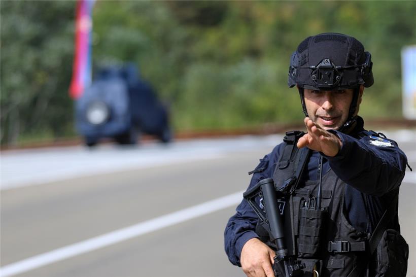 Ein Kosovo-Polizist bewacht eine Straße in der Nähe des Dorfes Banjska. Maskierte und schwer bewaffnete Angreifer haben im fast ausschließlich serbisch bewohnten Norden des Kosovo einen kosovarischen Polizisten erschossen. 
