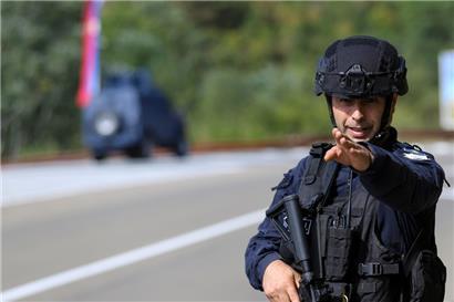 Ein Kosovo-Polizist bewacht eine Straße in der Nähe des Dorfes Banjska. Maskierte und schwer bewaffnete Angreifer haben im fast ausschließlich serbisch bewohnten Norden des Kosovo einen kosovarischen Polizisten erschossen. 
