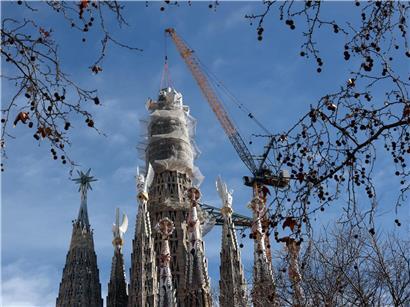 Kran hebt letztes Teilstück des 17 m hohen Kreuzes am Turm Jesu Christi der Sagrada Familia in Barcelona, Februar 2026