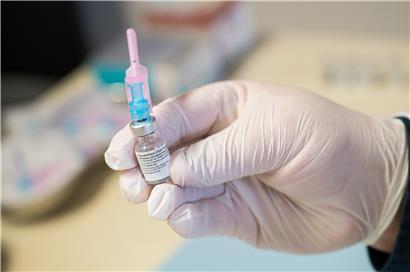 Ein Krankenpfleger hält ein Fläschchen mit dem Impfstoff gegen Covid-19 in der Hand
