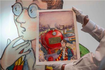 Ein Kunstsachbearbeiter hält Thomas Taylors Original-Cover für J.K. Rowlings „Harry Potter und der Stein der Weisen“
