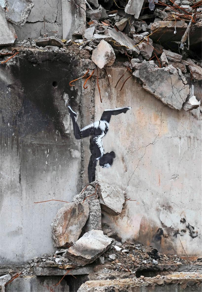 Ein Kunstwerk von Banksy an einem beschädigten Gebäude 
