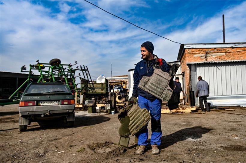 Ein Landwirt trägt kugelsichere Westen während der Aussaat, die 30 km von der Frontlinie entfernt stattfindet, Region Saporischschja, Südostukraine
