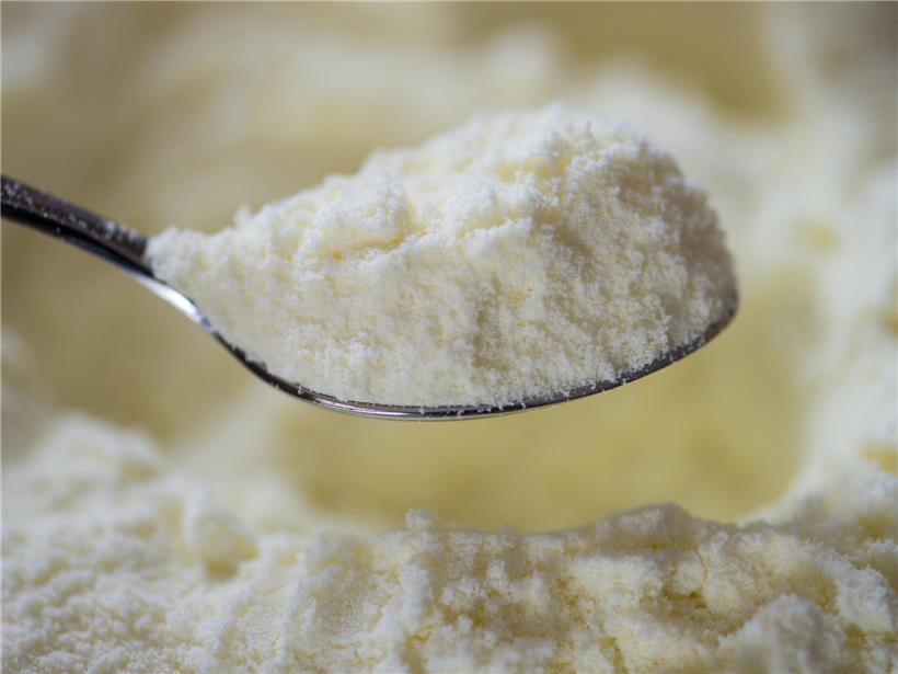 Löffel mit weißem Baby-Milchpulver zum Zubereiten von Säuglingsnahrung