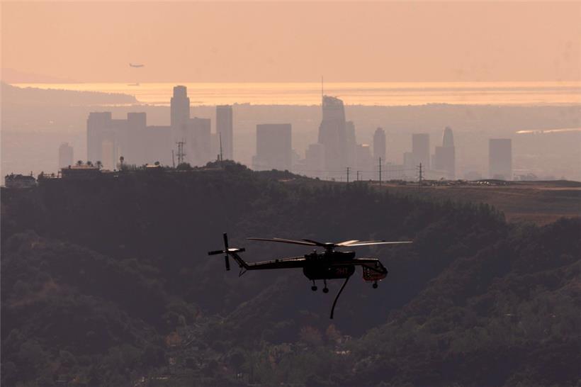 Ein Löschhubschrauber fliegt über die Innenstadt von Los Angeles
