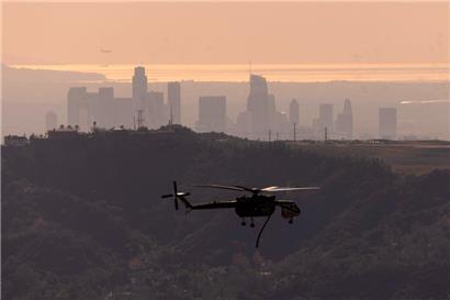 Ein Löschhubschrauber fliegt über die Innenstadt von Los Angeles
