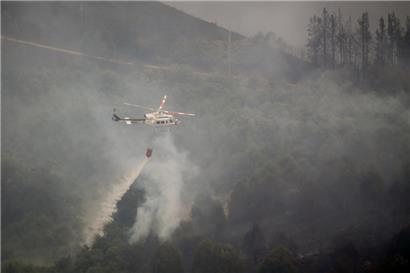 Ein Löschhubschrauber ist an den Löscharbeiten eines Waldbrandes in A Pobra do Brollon im Nordwesten Spaniens beteiligt
