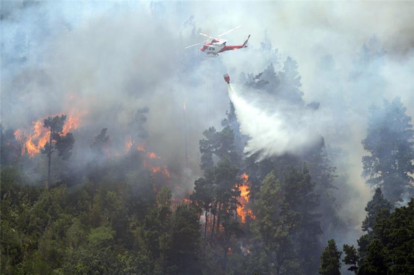 Ein Löschhubschrauber schüttet Wasser auf einen Waldbrand in Santa Cruz de Tenerife
