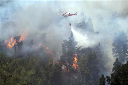 Ein Löschhubschrauber schüttet Wasser auf einen Waldbrand in Santa Cruz de Tenerife
