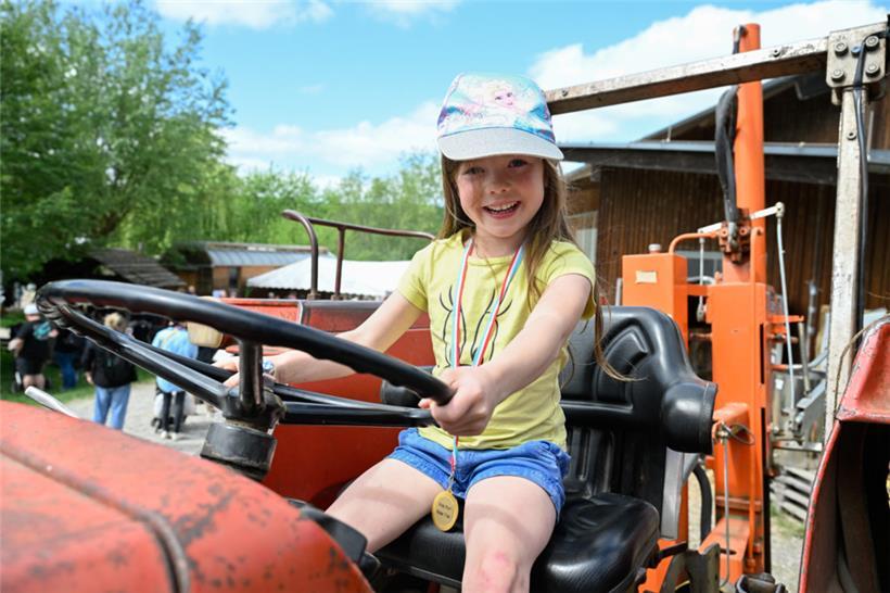 Ein Mädchen genießt die Aussicht auf einem Traktor
