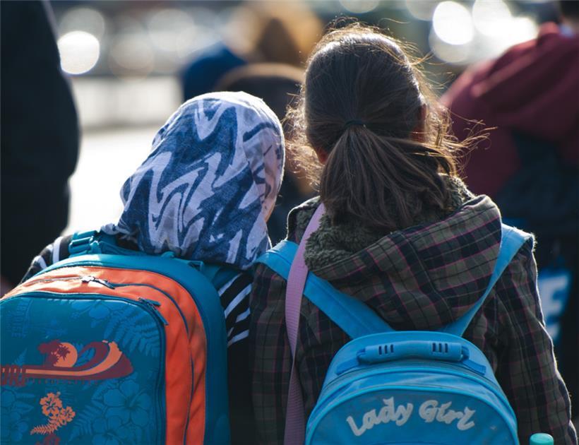 Ein Mädchen mit Kopftuch steht neben einem Mädchen ohne Kopftuch: In Österreichs Schulen sollen Mädchen unter 14 Jahren künftig kein Kopftuch tragen dürfen
