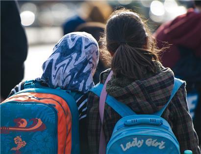 Ein Mädchen mit Kopftuch steht neben einem Mädchen ohne Kopftuch: In Österreichs Schulen sollen Mädchen unter 14 Jahren künftig kein Kopftuch tragen dürfen
