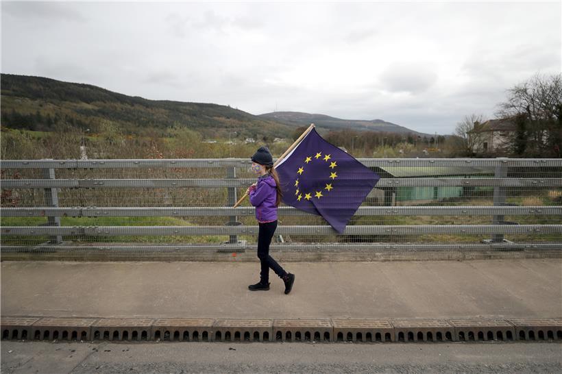 Ein Mädchen trägt eine EU-Flagge
