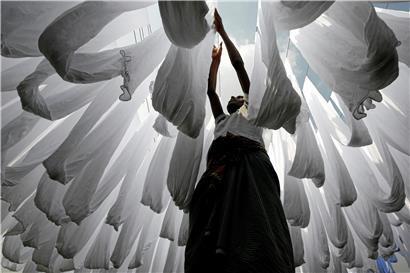 Ein Mann arbeitet in einer Tuchfabrik in Bangladesch: Beschäftigte in der Textilindustrie in Asien sind oft prekären Arbeitsbedingungen ausgesetzt
