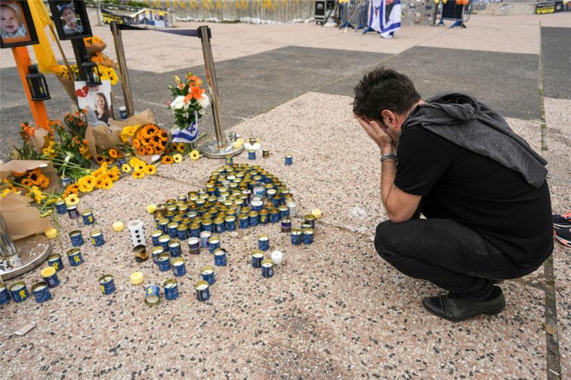 Ein Mann betet an einer Gedenkstätte für die verstorbenen Geiseln, die junge Mutter Schiri Bibas, ihre beiden kleinen Kinder Ariel und Kfir und den alten Mann Oded Lifshitz auf dem „Geiselplatz“ in Tel Aviv
