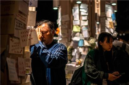 Ein Mann betet vor dem Wang Fuk Court nach dem tödlichen Brand vom 26. November im Stadtteil Tai Po in Hongkong

