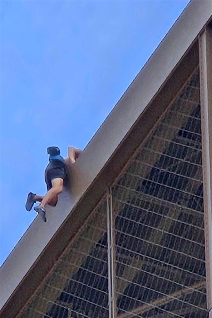 Ein Mann erklimmt den Eiffelturm
