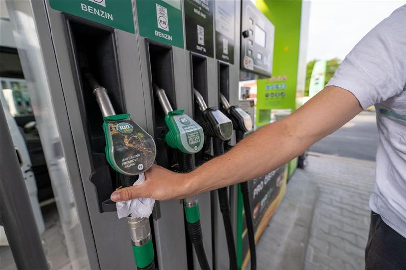 Mann tankt Auto an moderner Tankstelle mit Zapfhahn bei klarem Wetter