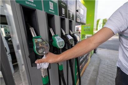 Mann tankt Auto an moderner Tankstelle mit Zapfhahn bei klarem Wetter