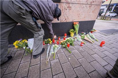 Ein Mann legt am Heumarkt in unmittelbarer Nähe eines Tatorts Blumen ab: Neun Menschen mit Migrationshintergrund wurden einfach hingerichtet, sechs zum Teil schwer verletzt
