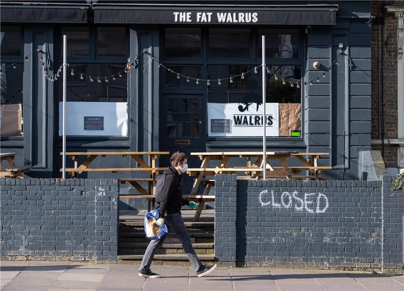 Ein Mann mit Mundschutz geht an einer geschlossenen Kneipe in New Cross im Süden Londons vorbei. In Großbritannien werden zur Eindämmung der Covid-19-Pandemie alle Pubs, Bars, Restaurants und Cafés geschlossen. Auch Nachtklubs, Theater, Kinos, Freizeitzentren und Sportstudios dürften nicht mehr betrieben werden.
