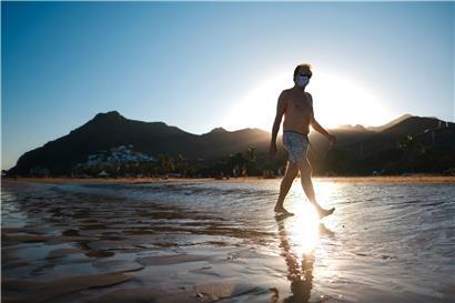 Ein Mann mit Mundschutz geht in Santa Cruz am Strand, als die Bundesregierung die Kanaren wegen steigender Infektionszahlen als Risikogebiet einstuft
