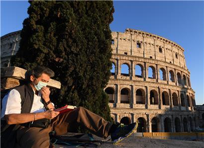 Ein Mann mit einer Gesichtsmaske liest vor dem Kolosseum ein Buch. Italien hebt ab dem 4. Mai eine Reihe von Beschränkungen auf und erlaubt mehr Bewegungsmöglichkeiten in der eigenen Region.
